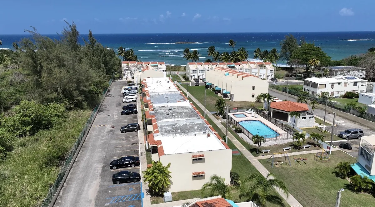 Aerial drone photo of a beachfront condo complex with pool in Puerto Rico, shot by Zoom Realty Services