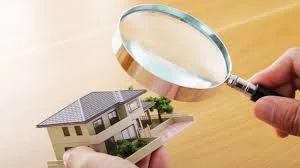 Model home being examined with a magnifying glass during a property inspection